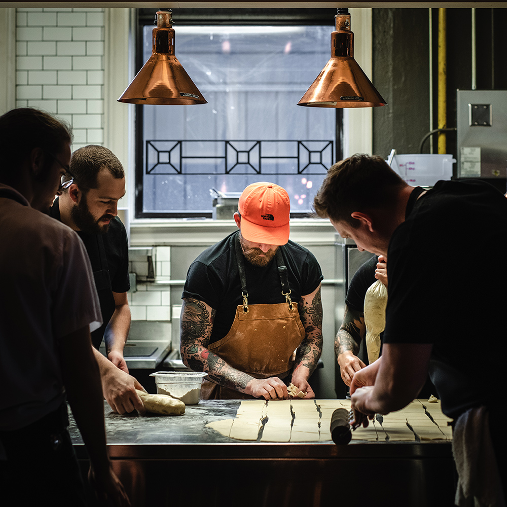 Chef making food with his team in a kitchen on the Scenic Eclipse