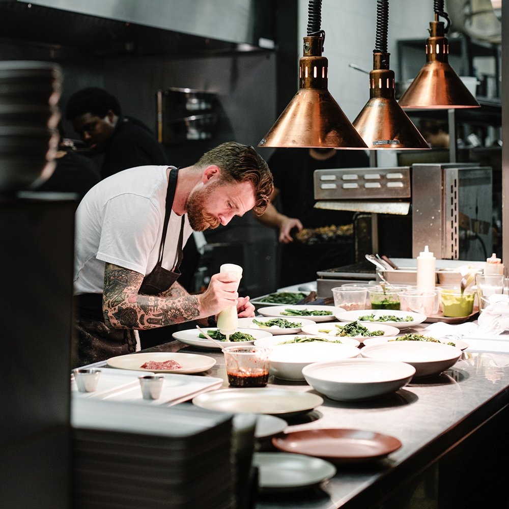 Chef preparing food in a kitchen on the Scenic Eclipse